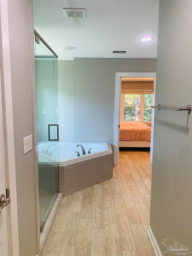 bathroom featuring shower with separate bathtub and hardwood / wood-style flooring