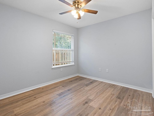 empty room featuring ceiling fan, baseboards, and wood finished floors