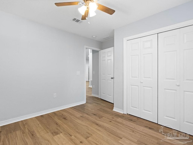 unfurnished bedroom featuring light wood-type flooring, baseboards, visible vents, and a closet