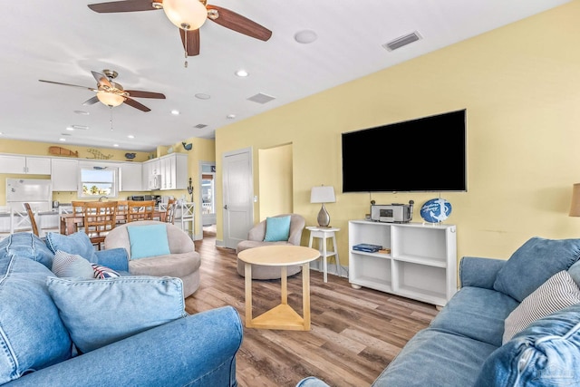 living room with light hardwood / wood-style floors and ceiling fan