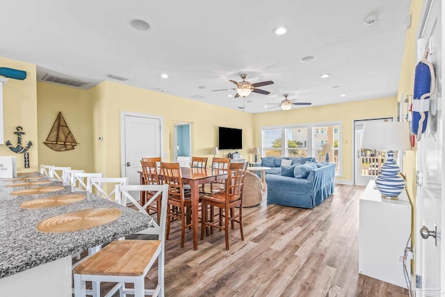 dining space with hardwood / wood-style floors and ceiling fan