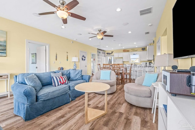 living room with ceiling fan and light wood-type flooring