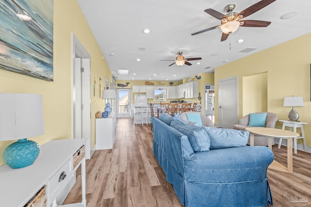 living room featuring light hardwood / wood-style floors and ceiling fan