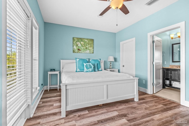 bedroom featuring connected bathroom, wood-type flooring, and ceiling fan