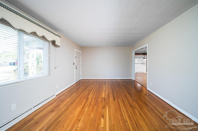 spare room featuring hardwood / wood-style floors and a baseboard radiator