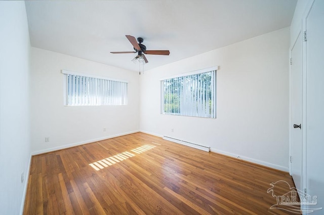 empty room with ceiling fan, wood-type flooring, and baseboard heating