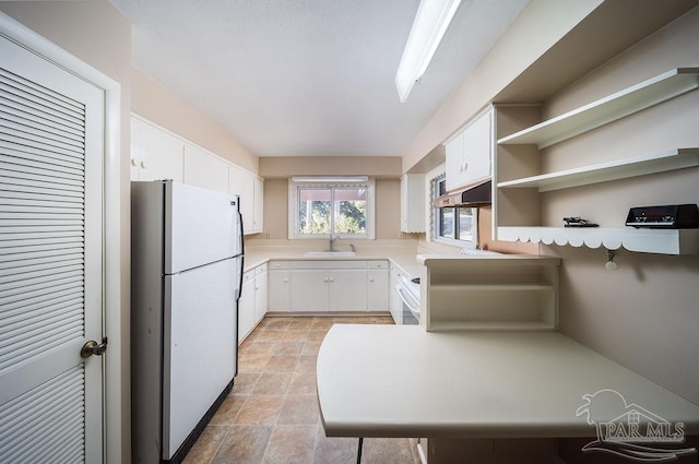 kitchen with sink, white cabinets, exhaust hood, and white refrigerator