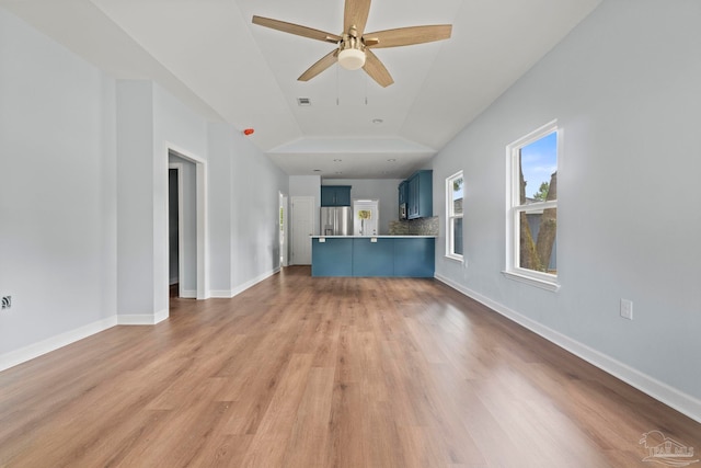 unfurnished living room with ceiling fan, lofted ceiling, and light hardwood / wood-style flooring