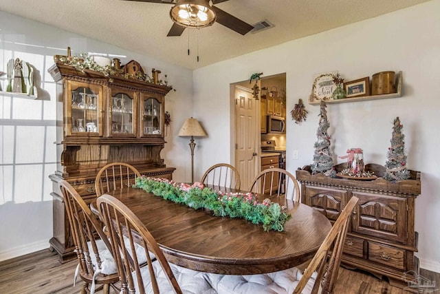 dining area with a textured ceiling, hardwood / wood-style flooring, and a wealth of natural light