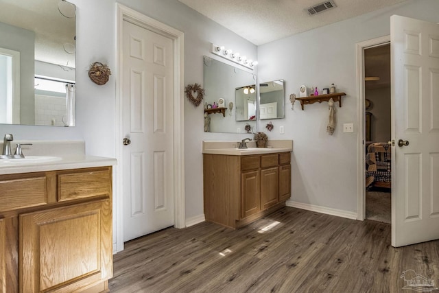 bathroom featuring hardwood / wood-style floors, vanity, and a textured ceiling