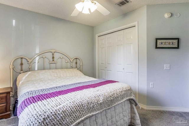 bedroom with a textured ceiling, carpet floors, a closet, and ceiling fan