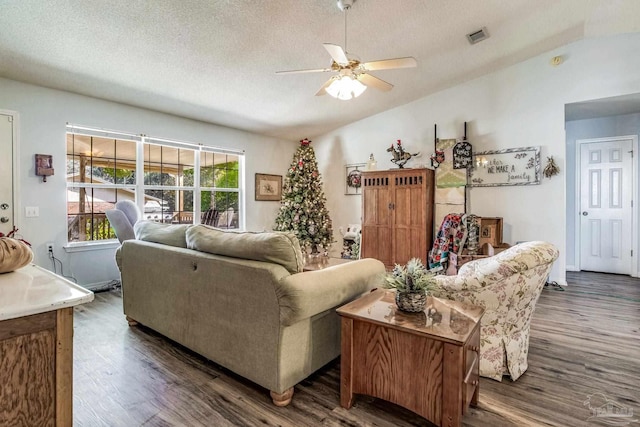 living room featuring a textured ceiling, lofted ceiling, ceiling fan, and dark wood-type flooring