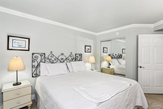 bedroom with light tile patterned floors, crown molding, and a closet