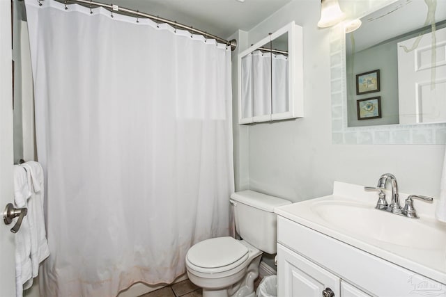 bathroom featuring vanity, tile patterned floors, toilet, and walk in shower