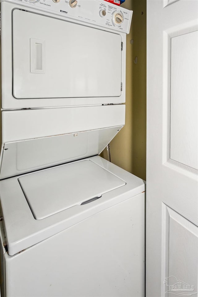 washroom with stacked washing maching and dryer