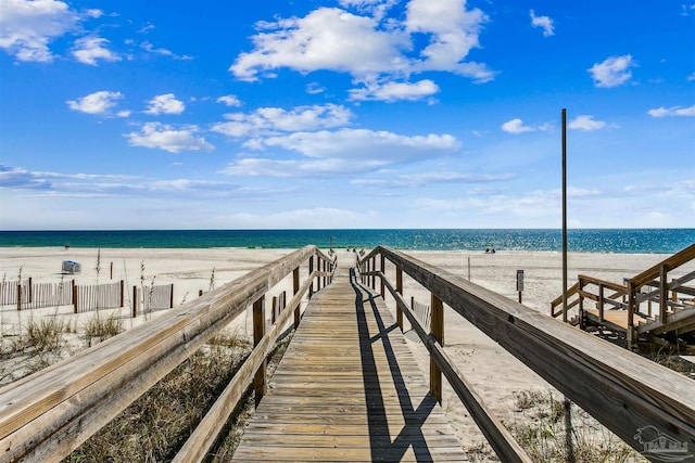 view of dock featuring a beach view and a water view