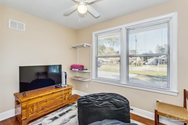 sitting room with hardwood / wood-style floors and ceiling fan