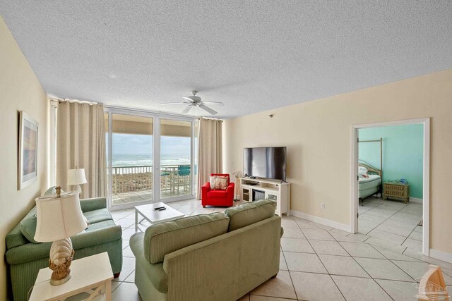 tiled living room with ceiling fan and a textured ceiling