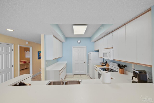 kitchen with white cabinetry, white appliances, light tile patterned floors, a textured ceiling, and sink