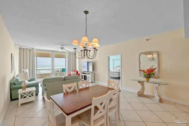 dining space featuring a textured ceiling, light tile patterned floors, and ceiling fan with notable chandelier