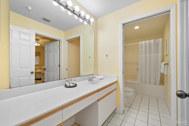 full bathroom featuring shower / bath combination with curtain, toilet, vanity, ceiling fan, and tile patterned floors