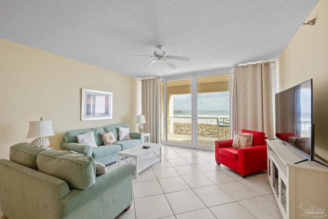 living room with floor to ceiling windows, light tile patterned flooring, ceiling fan, and a textured ceiling