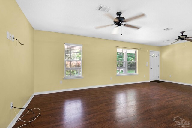 empty room featuring plenty of natural light, ceiling fan, and hardwood / wood-style flooring