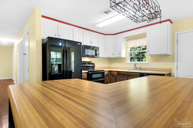 kitchen featuring black appliances, white cabinets, sink, crown molding, and hardwood / wood-style flooring