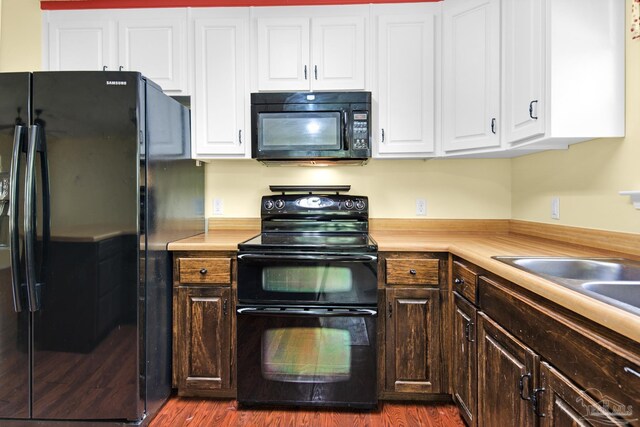 kitchen featuring white cabinetry, black appliances, and hardwood / wood-style floors