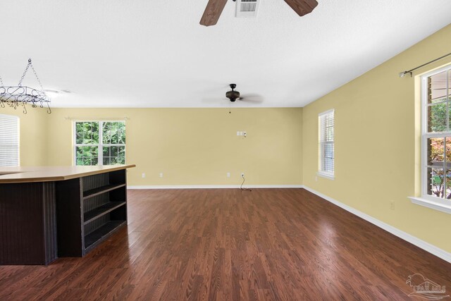 unfurnished room featuring dark hardwood / wood-style floors, a wealth of natural light, and ceiling fan