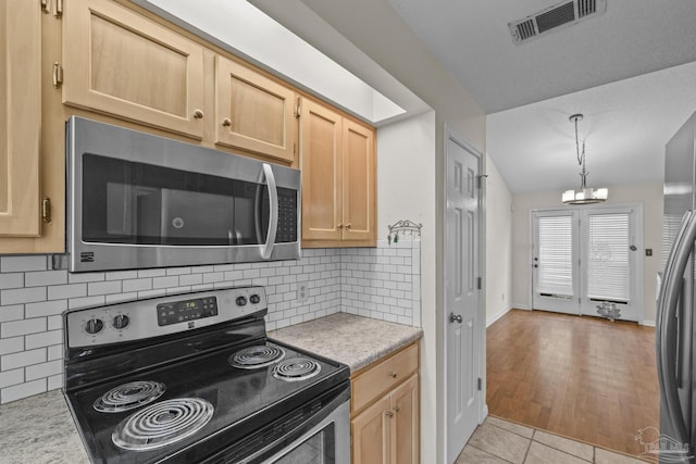 kitchen with light countertops, visible vents, appliances with stainless steel finishes, and light brown cabinetry