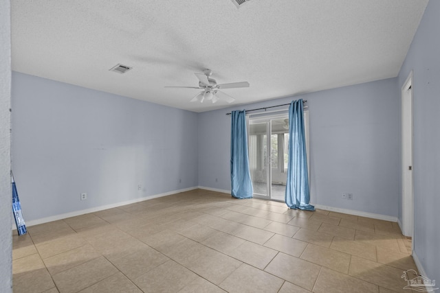 unfurnished room with visible vents, baseboards, a textured ceiling, and ceiling fan