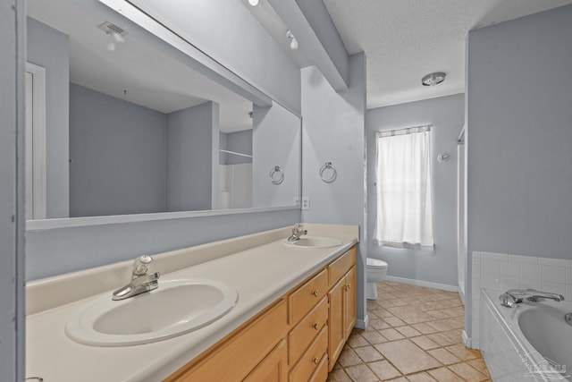 full bath featuring double vanity, a textured ceiling, toilet, and a sink