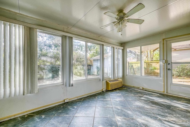 unfurnished sunroom featuring ceiling fan and a wall mounted AC