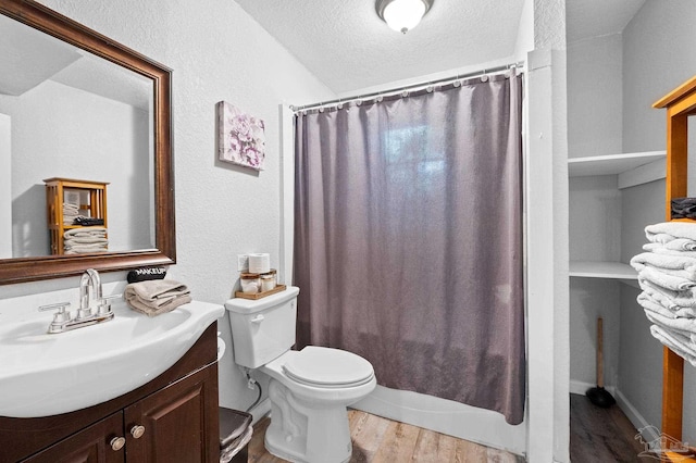 full bathroom with shower / bath combination with curtain, wood-type flooring, a textured ceiling, toilet, and vanity