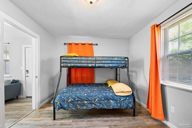 bedroom with hardwood / wood-style floors and a textured ceiling