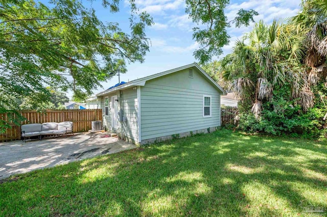 view of side of home with a yard, a patio, and cooling unit