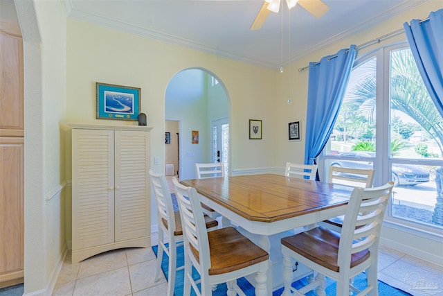 tiled dining room with ornamental molding and ceiling fan