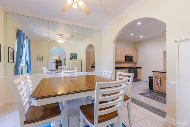 tiled dining space featuring crown molding and ceiling fan