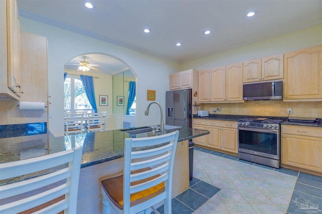 kitchen featuring light brown cabinetry, sink, stainless steel appliances, and backsplash