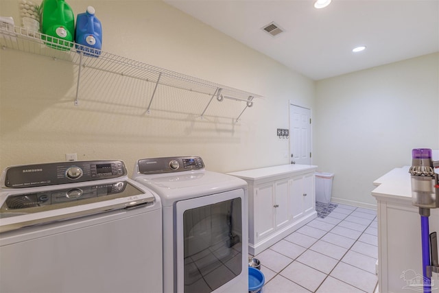 laundry area with light tile patterned floors, cabinets, and independent washer and dryer