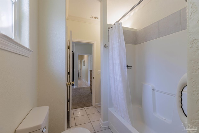 bathroom featuring shower / tub combo with curtain, tile patterned flooring, and toilet