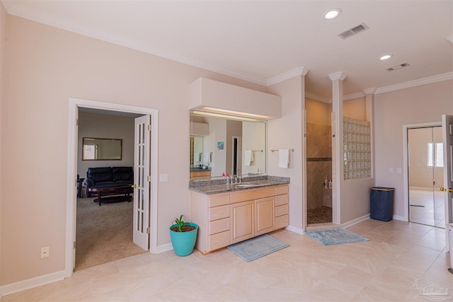 bathroom featuring tile patterned flooring, walk in shower, crown molding, and vanity