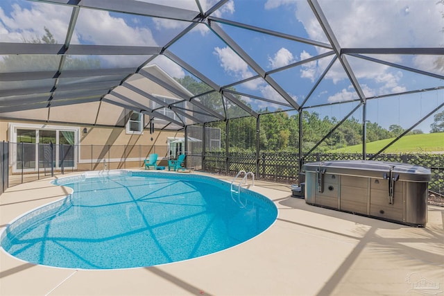 view of pool featuring glass enclosure, a patio, and a hot tub