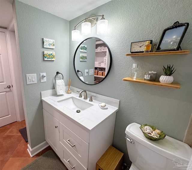 half bath featuring a textured wall, toilet, vanity, and tile patterned flooring