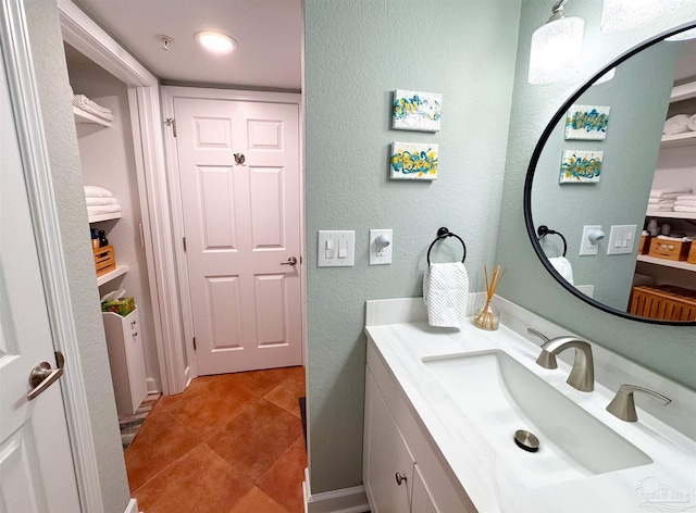 bathroom featuring a textured wall, vanity, and tile patterned flooring