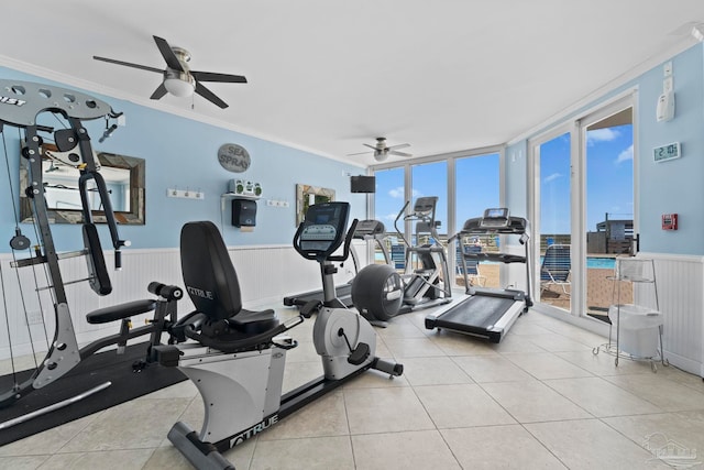 workout area with tile patterned floors, wainscoting, a ceiling fan, and crown molding