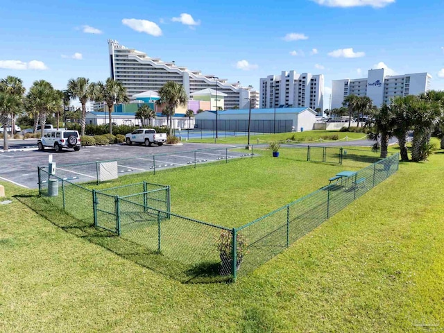 surrounding community featuring a gate, fence, a yard, and uncovered parking