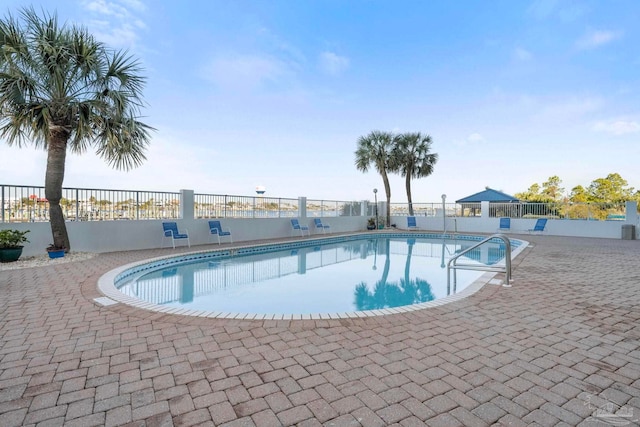 community pool featuring a patio and fence