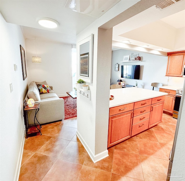 kitchen with light tile patterned floors, open floor plan, electric stove, and light countertops